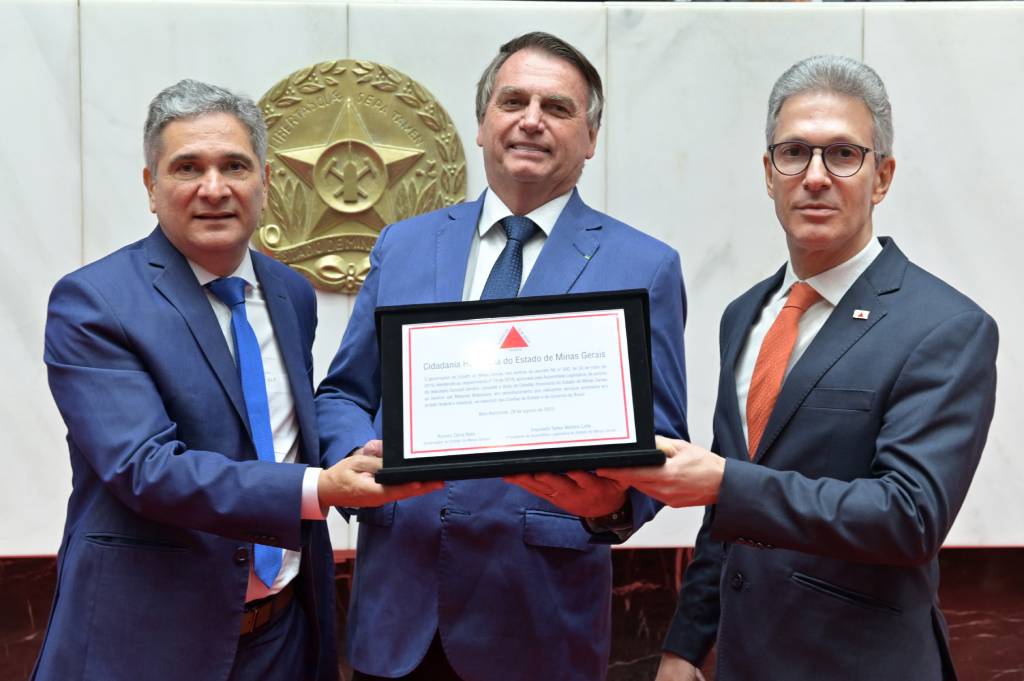 Jair Bolsonaro com o diploma de cidadão honorário, entre o deputado Coronel Sandro e o governador Romeu Zema (Foto: Luiz Santana)