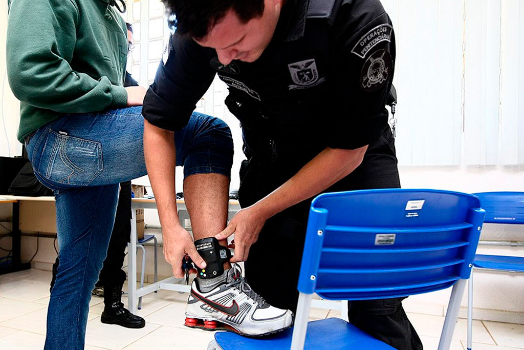 Policial penal instala equipamento de monitoração eletrônica (tornozeleira) em detento Foto: Sec. Justiça do Paraná 